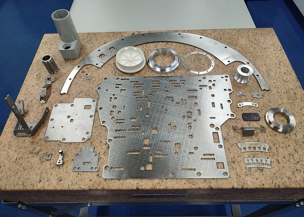 cut metal parts laid out in order on a table